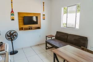 巴纳伊巴Otimo chale c WiFi e boa localizacao - Parnaiba PI的客厅配有沙发和墙上的电视
