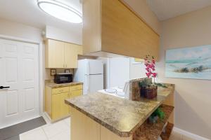 奥兰多Evergreen Escape的厨房配有柜台和白色冰箱。