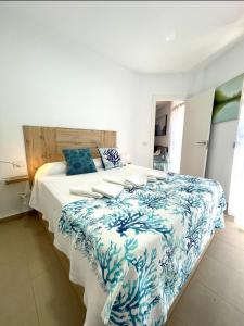 特尔德SeawaveSunGranCanaria的一间卧室配有一张大床,提供蓝白色的毯子