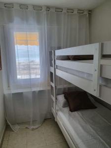 卡斯特尔德费尔斯Beach front room NOT A HOTEL的一间卧室设有两张双层床和一扇窗户。