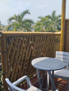 帕洛米诺La Rivera Playa Palomino的棕榈树阳台的桌椅