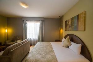 内罗毕Taarifa Suites by Dunhill Serviced Apartments的酒店客房,配有床和沙发