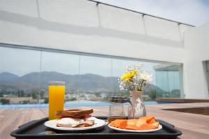 特皮克hotel vista valle的盘子,盘子上放着两盘食物和一杯橙汁
