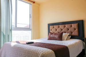 波哥大Hotel Casa Botero 305的一间卧室配有一张带枕头和窗户的床