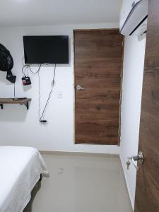 卡塔赫纳HOTEL DI MAR的一间卧室配有一张床,墙上配有电视