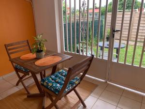 卡宴Le nid du Kikiwi , refuge relaxant avec jardin的桌子、椅子、桌子和窗户