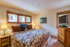 特柳赖德Aspen Ridge 32 - 2 bedroom townhouse的一间卧室配有一张床和一台平面电视