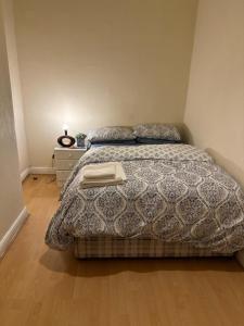 达灵顿Mortiara的一间卧室配有一张带毯子和床头柜的床