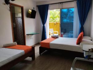 帕洛米诺La Rivera Playa Palomino的一间卧室设有两张床和一个美景窗户。