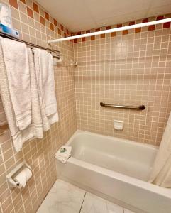 迈阿密布罗城堡酒店的浴室配有白色浴缸和毛巾。