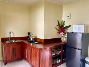 卢甘维尔Lapita Beach Aore Island Vanuatu的厨房配有木制橱柜和不锈钢冰箱。