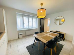 特里尼亚克Appartement Confortable - Trignac Centre Ville的一间带桌椅和镜子的用餐室