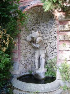科洛迪Fattoria Gambaro di Petrognano的靠在石墙上的人的雕像