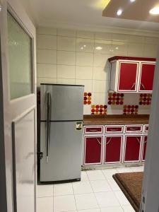 亚历山大Tyvally Dom apartment sea view للعائلات فقط的厨房配有白色冰箱和红色橱柜