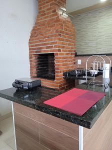 吉巴拉那Casa agradável com área gourmet的厨房在柜台上设有砖砌壁炉