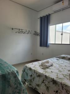 吉巴拉那Casa agradável com área gourmet的一间卧室设有一张床和一个窗口