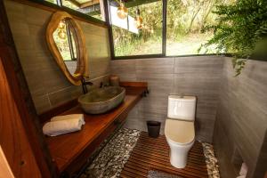 马尼萨莱斯Owl's Watch Nature Retreat的一间带水槽、卫生间和镜子的浴室