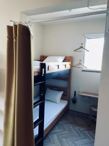 淡路ゲストハウス and BAR CHITEN的客房设有两张双层床和一张书桌。