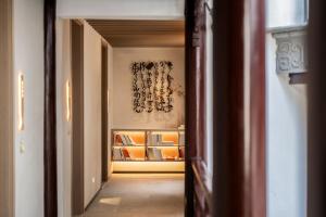 南京南京夜泊秦淮尊经书院酒店的走廊通往带架子的房间