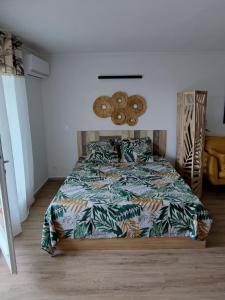 哥西尔Studio de charme au Gosier的一间卧室配有一张带五颜六色棉被的床