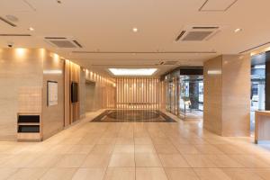 大阪The OneFive Osaka Namba Dotonbori的建筑的走廊,铺有瓷砖地板