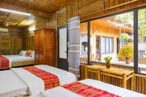 枚州县Mai Chau Moment Spa & Resort的一间卧室设有两张床和窗户。