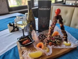ChereshaХотел “Райски кът”的桌上的一盘食物和一瓶葡萄酒