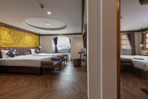 萨帕Hôteldesapa的酒店客房设有两张床和窗户。