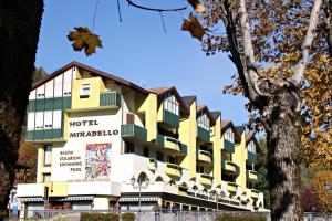 费拉迪普利米罗Hotel Mirabello - Slow Hotel Benessere的拥有黄色和白色建筑的酒店