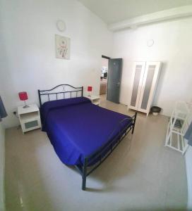努格古达宾至如归度假屋的一间卧室配有一张带紫色毯子的床