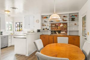 圣巴巴拉Colorful Gold Coast Getaway的厨房配有木桌和白色橱柜。
