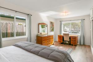 圣巴巴拉Colorful Gold Coast Getaway的一间卧室配有一张床、一张书桌和一面镜子