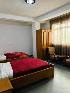 亚的斯亚贝巴Goza Guest House 22的一间卧室配有两张床和一张桌子及椅子