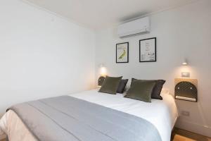 圣地亚哥Comodo y Moderno Depto 2D1B en Santiago HOM的卧室配有带绿色枕头的大型白色床