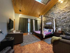 西姆拉SaffronStays Ekam, Chail - forest villa near Chail cricket ground的一间带床和石墙的客厅