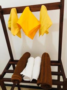 陶尔佩The villa on the Rock的毛巾架,带两条毛巾和一些黄纸