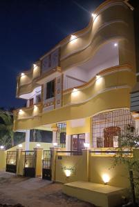 蓬蒂切里La Shashalia Luxury的一座黄色和白色的建筑,灯火通明
