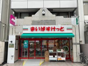 东京HARMONIA東京堀切 10名定員90平米の広いCondominium的前面有标牌的商店