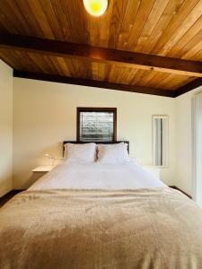 布拉格堡Pacific Sands Vacation Home的一间卧室设有一张带木制天花板的大床