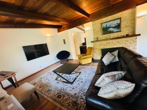 布拉格堡Pacific Sands Vacation Home的客厅配有真皮沙发和电视