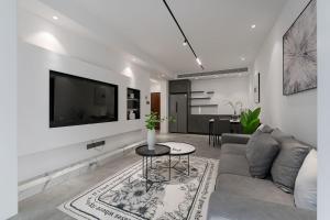 上海豪华大一房 黑白灰现代风 设计师品牌 中央空调的客厅配有沙发和墙上的电视