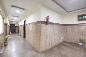 新德里RTS Hotel Delhi Airport的带有木墙的走廊,位于一个种植了盆栽植物的房间
