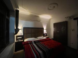 马拉里Hotel Premier Mall Road Manali的一间卧室配有一张带红色毯子的大床