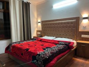 马拉里Hotel Premier Mall Road Manali的一间卧室配有一张带红色毯子的大床