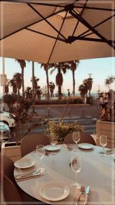 特拉维夫Bugrashov Beach 88 Hotel And Spa的一张桌子、酒杯和雨伞