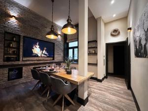 汉堡Black Suite 2 Luxus in Alsternähe的砖墙上的带桌子和电视的用餐室