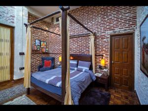 KandāghātSaffronStays Ekam Walnut Suite, Chail的卧室配有一张位于砖墙的天蓬床