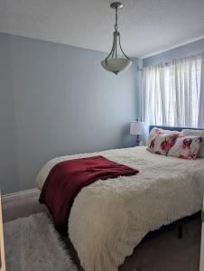 埃德蒙顿The Love Love Stay的一间卧室配有一张带红色毯子的床和窗户。