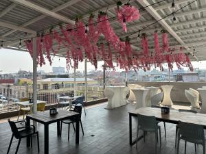 危地马拉Villa Verona的餐厅设有桌椅和粉红色吊灯。