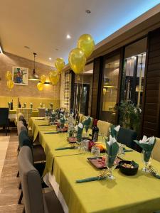 奥格尼亚诺沃Family Hotel Ognyanovo的餐馆里一排带黄色气球的桌子